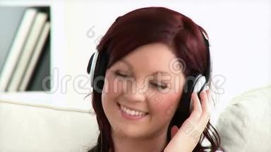 可爱的年轻女子戴着耳机听音乐